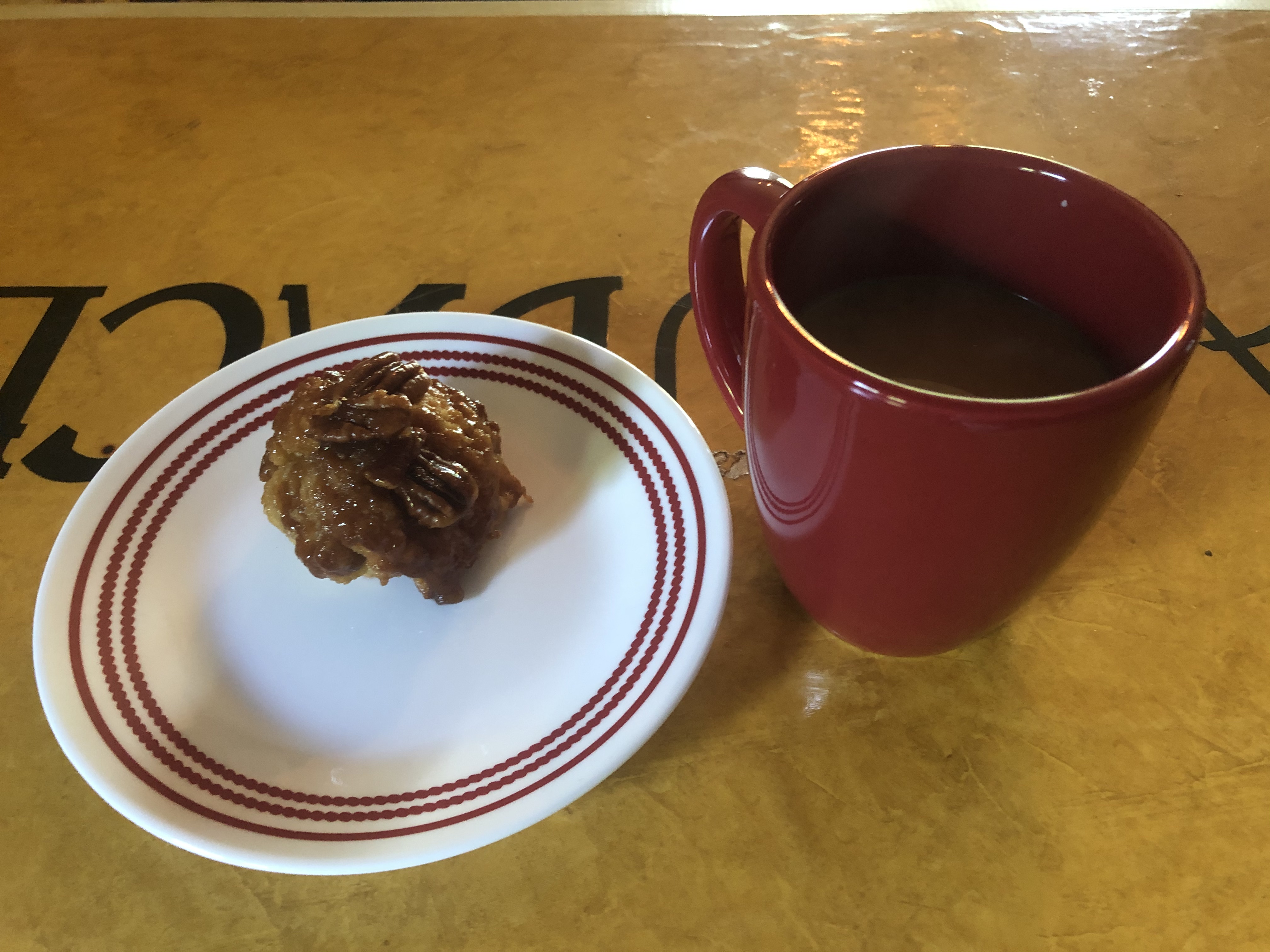 sticky bun on plate with coffee cup